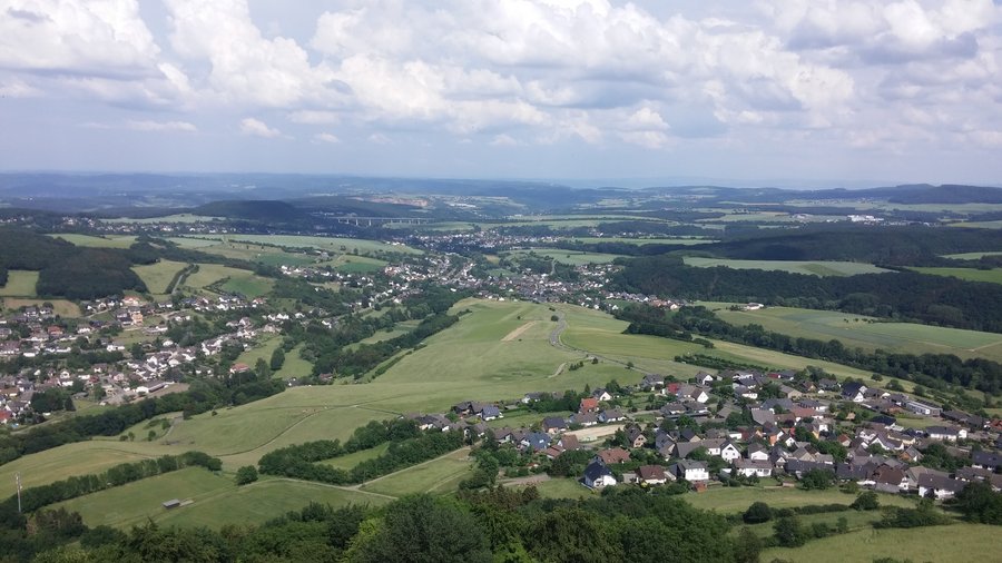 Landschaft mit Wiesen, Wald und Dörfern aus der Vogelperspektive.